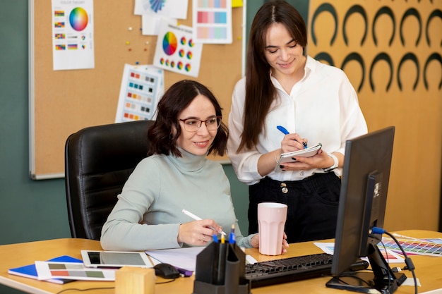 Photo gratuite plan moyen femmes travaillant ensemble