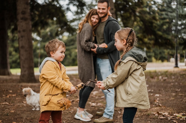 Photo gratuite plan moyen heureux parents regardant les enfants