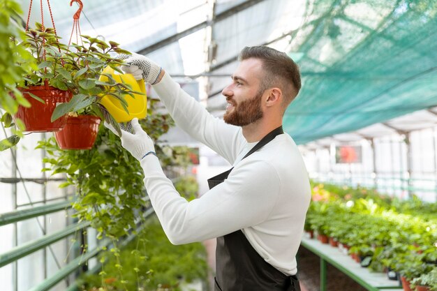 Plan moyen homme arrosant les plantes