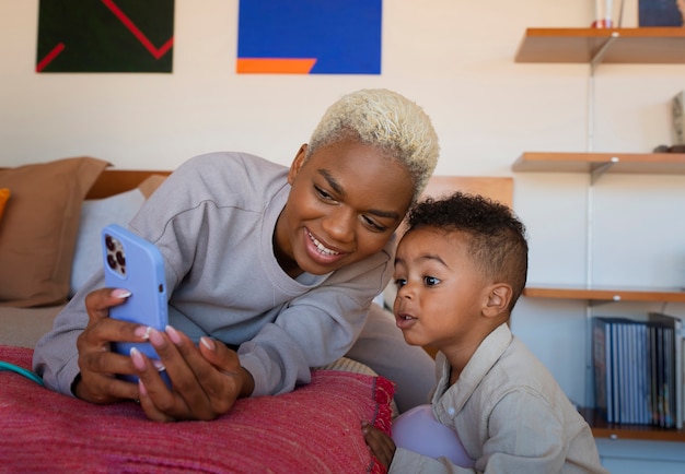 Plan moyen mère et enfant prenant selfie