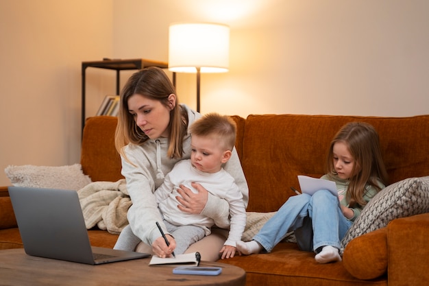 Photo gratuite plan moyen mère travaillant à distance