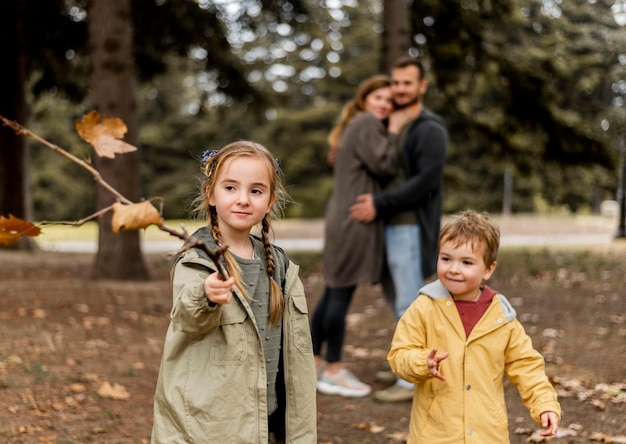 Plan moyen des parents heureux regardant les enfants