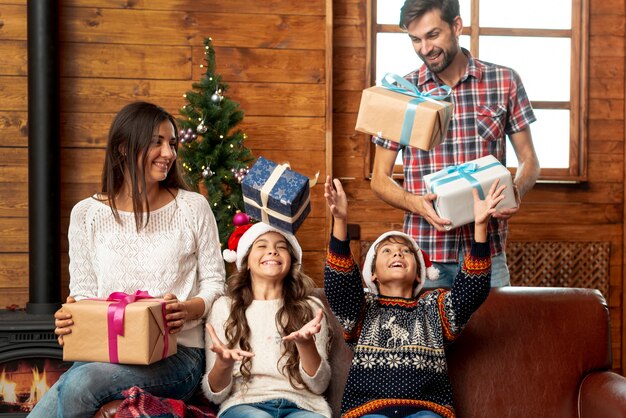 Plan moyen parents surprenant les enfants avec des cadeaux