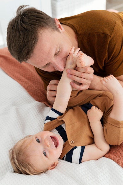 Plan moyen père embrassant enfant