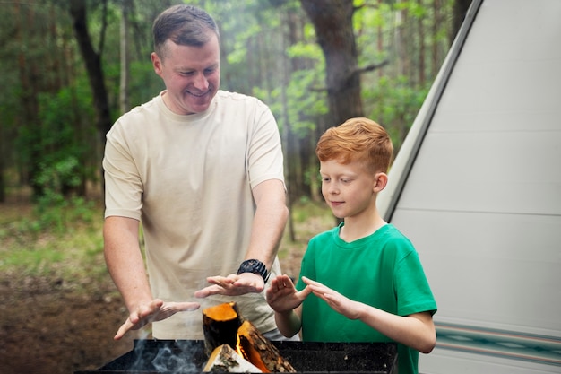 Photo gratuite plan moyen père et enfant près du feu