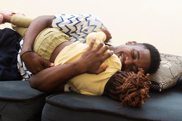 Plan moyen père et fille sur canapé