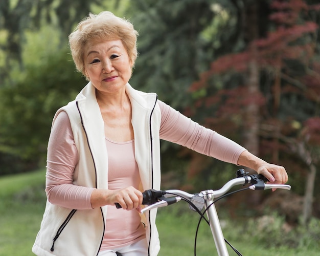 Plan moyen vieille femme tenant un vélo