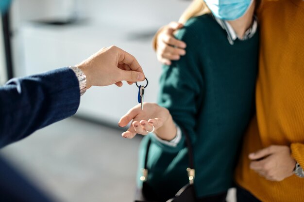 Plan rapproché d'un couple recevant la clé de leur nouveau bien immobilier