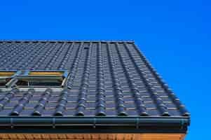 Photo gratuite plan rapproché à faible angle vertical du toit noir d'un immeuble