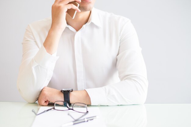 Plan rapproché de l&#39;homme en appelant sur un smartphone au bureau