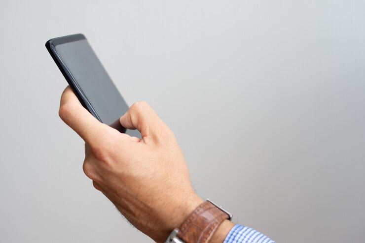 Photo gratuit plan rapproché d&#39;un homme tenant un smartphone et touchant son écran