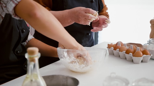 Plan rapproché des mains de petite-fille préparant la pâte traditionnelle faite maison de biscuits