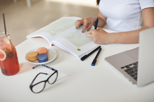 Plan recadré mains de femme écrivant des notes étudiant s'asseoir dans un café