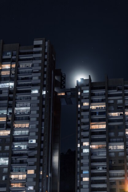 Plan vertical de beaux immeubles d'appartements reliés à un court pont sous le ciel étoilé