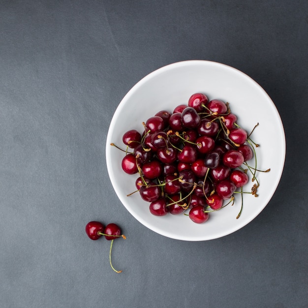 Plan vertical d'un bol de cerises rouges