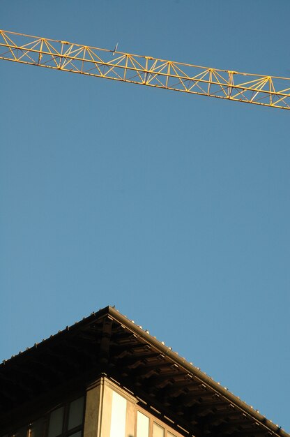 Plan vertical du toit d'un bâtiment et d'une grue avec un ciel clair