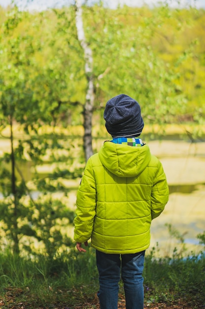 Plan vertical d'un enfant avec un manteau jaune jouant dans l'aire de jeux