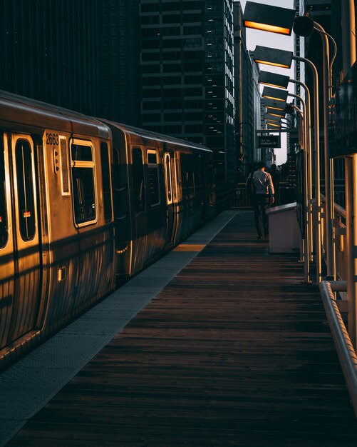 Plan vertical d'une gare avec le train pendant le lever du soleil