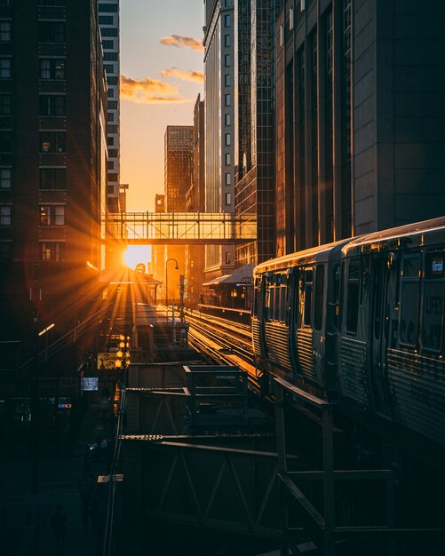 Plan vertical d'une gare avec le train pendant le lever du soleil