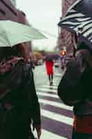 Photo gratuite plan vertical d'un groupe de personnes marchant dans la rue sous la pluie