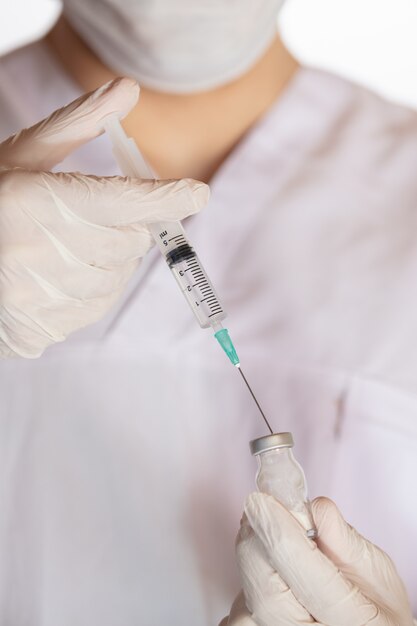 Plan vertical d'un médecin détenant un vaccin - le concept du virus corona
