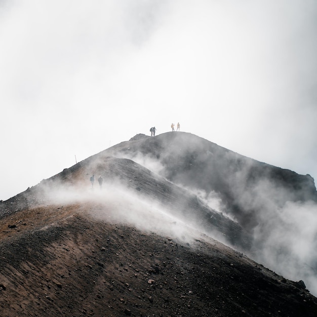 Plan vertical de voyageurs au sommet d'une montagne brumeuse