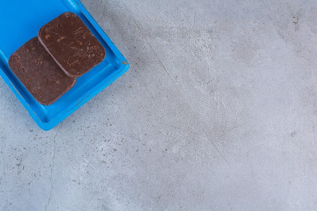 Une planche en bois bleue de biscuits au chocolat sur fond gris