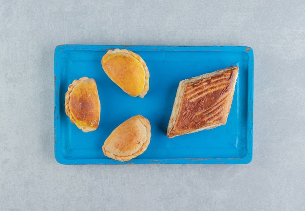 Une planche en bois bleue pleine de biscuits sucrés.