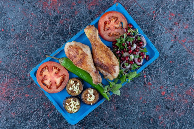 Une planche en bois bleue de viande de poulet grillée.