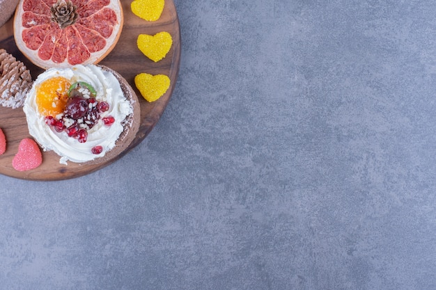 Une Planche De Bois Avec Des Bonbons Et Des Biscuits à La Gelée Sucrée