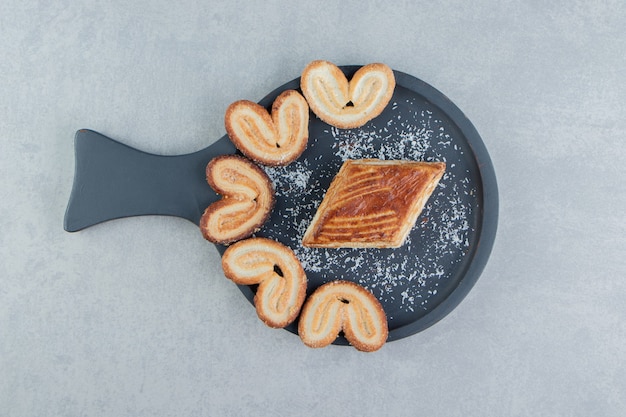 Une Planche En Bois Foncé Avec Des Biscuits En Forme De Coeur Doux.