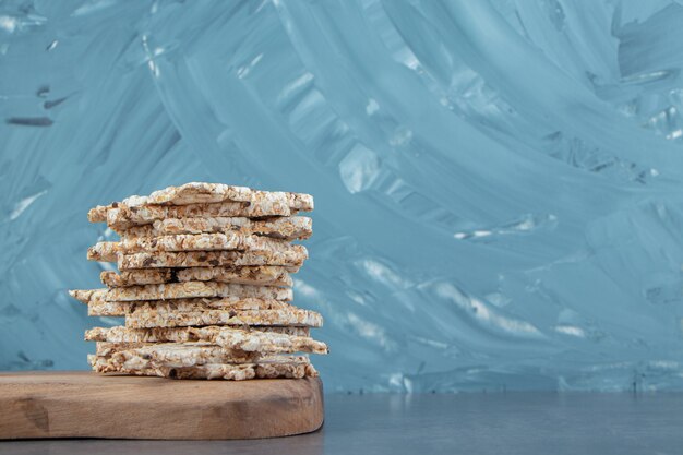 Une planche en bois de gaufres de riz carrées croustillantes.