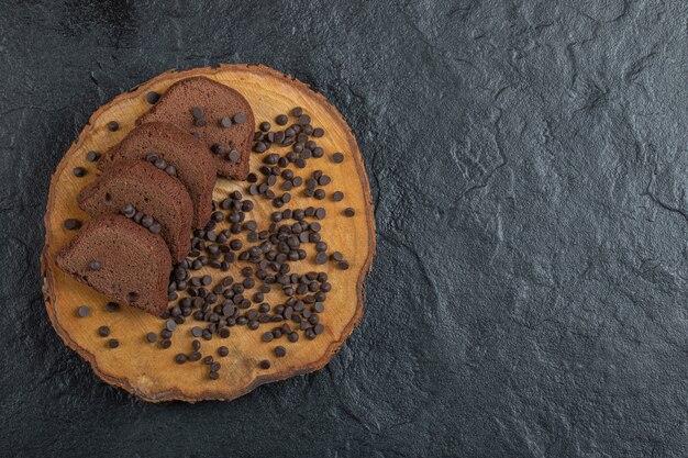 Une planche en bois de pépites de chocolat et de tranches de pain.