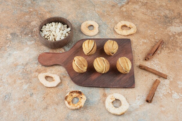 Une planche de bois pleine de biscuits sucrés et de bâtons de cannelle