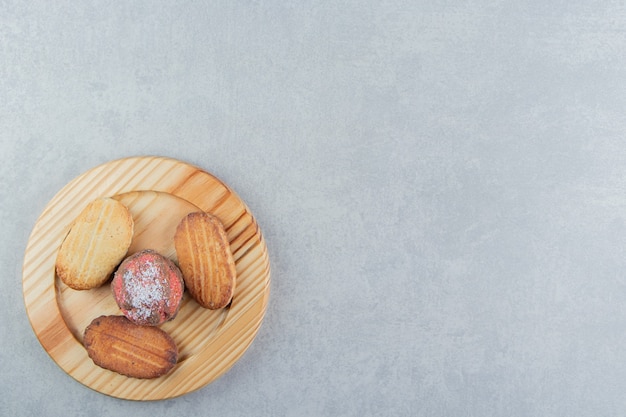 Une planche en bois pleine de biscuits sucrés.