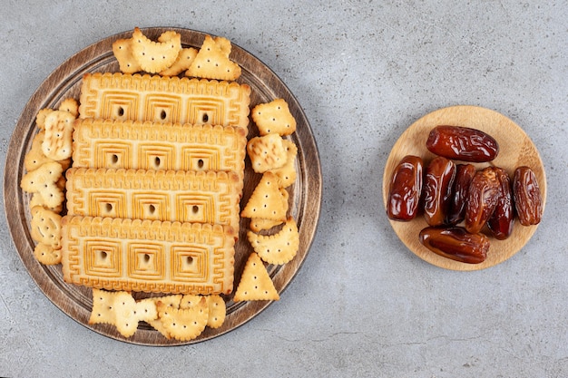 Une planche de bois pleine de biscuits sur une surface en marbre