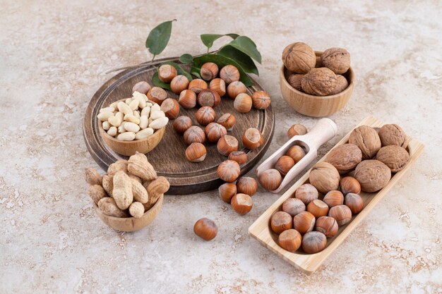 Une planche de bois pleine de noix de macadamia saines.