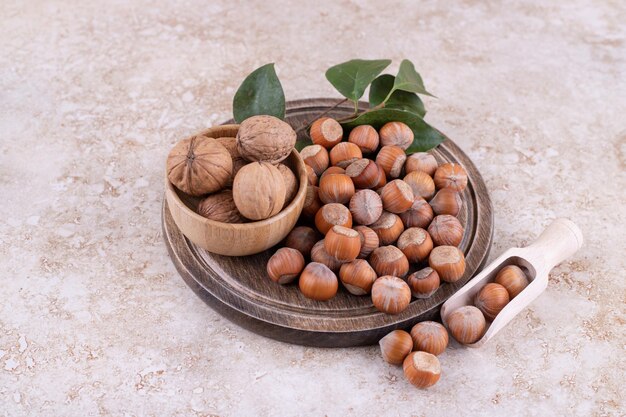 Une planche de bois pleine de noix de macadamia saines.