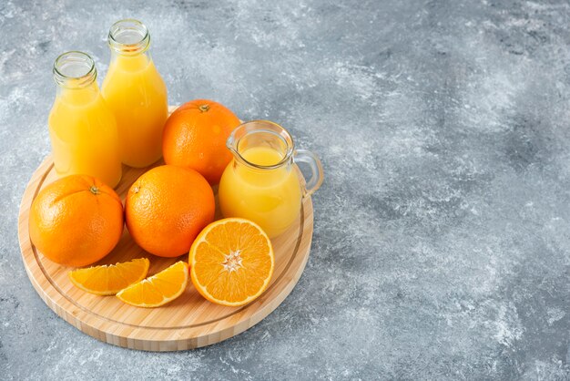 Une planche de bois pleine de tranches juteuses de fruits orange sur table en pierre.