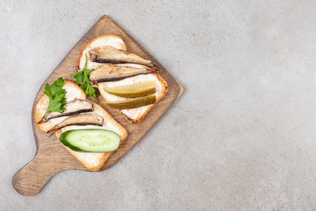 Une planche de bois avec des toasts frits et des sprats