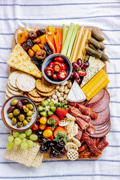 Photo gratuite planche de charcuterie avec charcuterie, fruits frais et fromage en gros plan