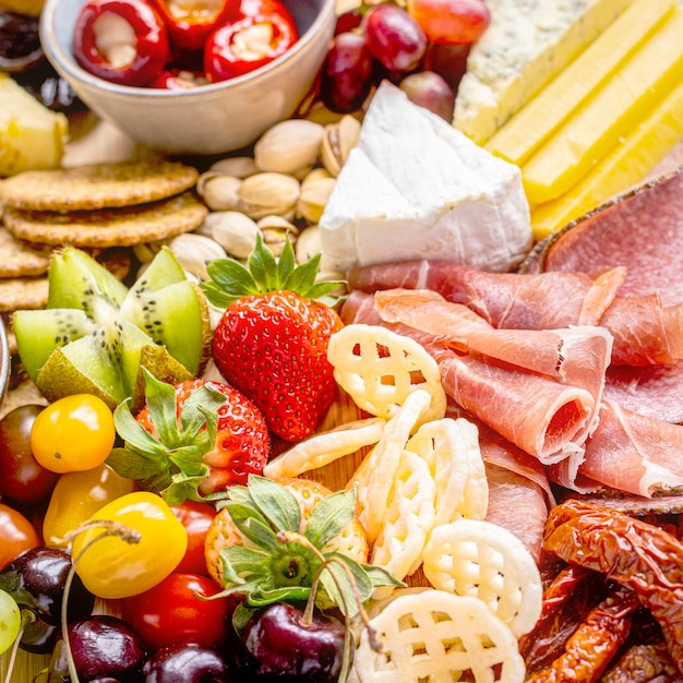 Planche de charcuterie avec charcuterie, fruits frais et fromage