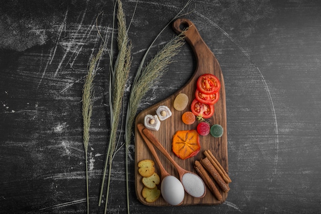 Planche à collation avec œuf, tomates et pâtisseries au centre