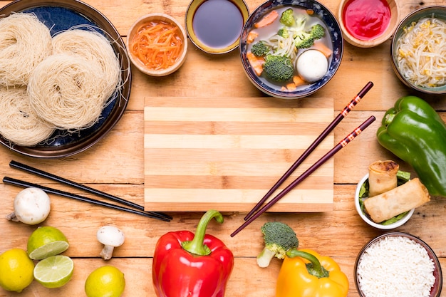 Planche à découper avec des baguettes tartinées de plats thaïlandais traditionnels