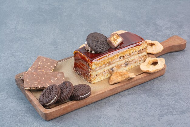 Une planche à découper en bois de biscuits et morceau de gâteau