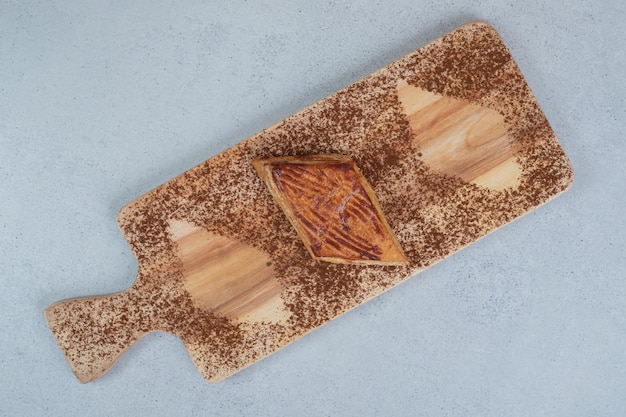 Une planche à découper en bois avec du cacao en poudre et des biscuits