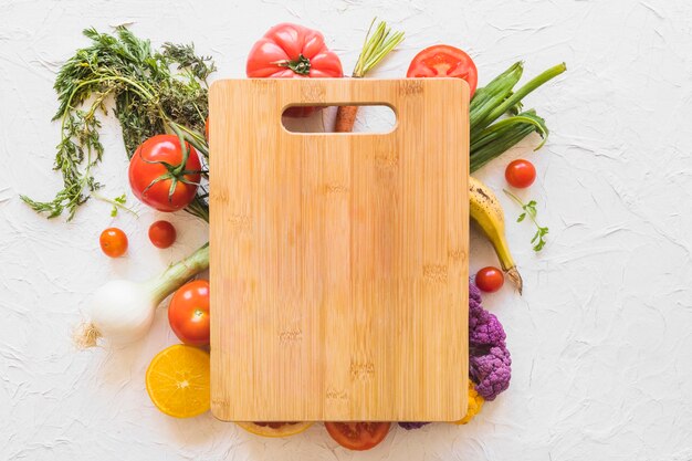 Planche à découper en bois sur les légumes sur fond de texture