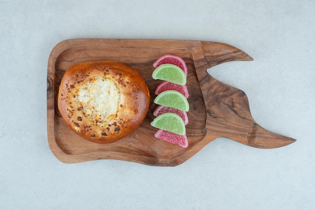 Une planche à découper en bois avec de la pâte ronde et des bonbons à la gelée.