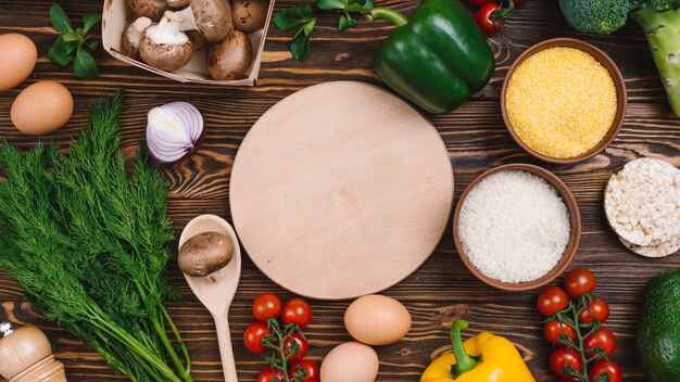 Planche à découper circulaire avec des légumes frais sur une table