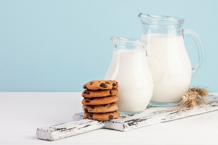 Photo gratuit planche à découper avec des cruches de lait